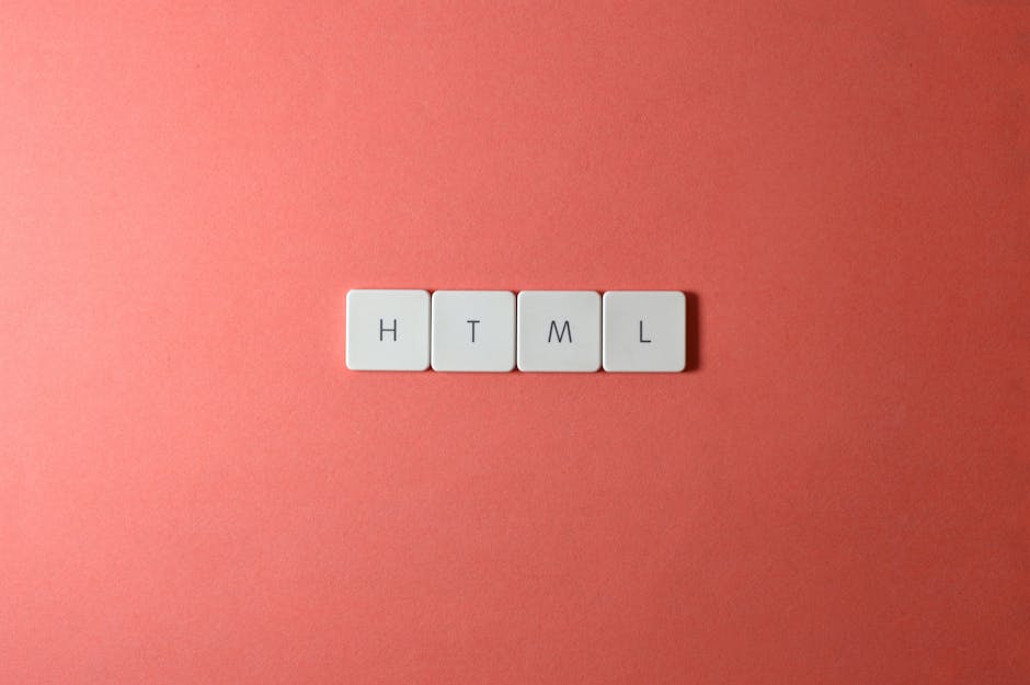 A close-up image of four white square tiles with black letters spelling 'HTML' arranged horizontally on a soft pink background. The tiles are evenly spaced, with the letters clearly visible. The backg